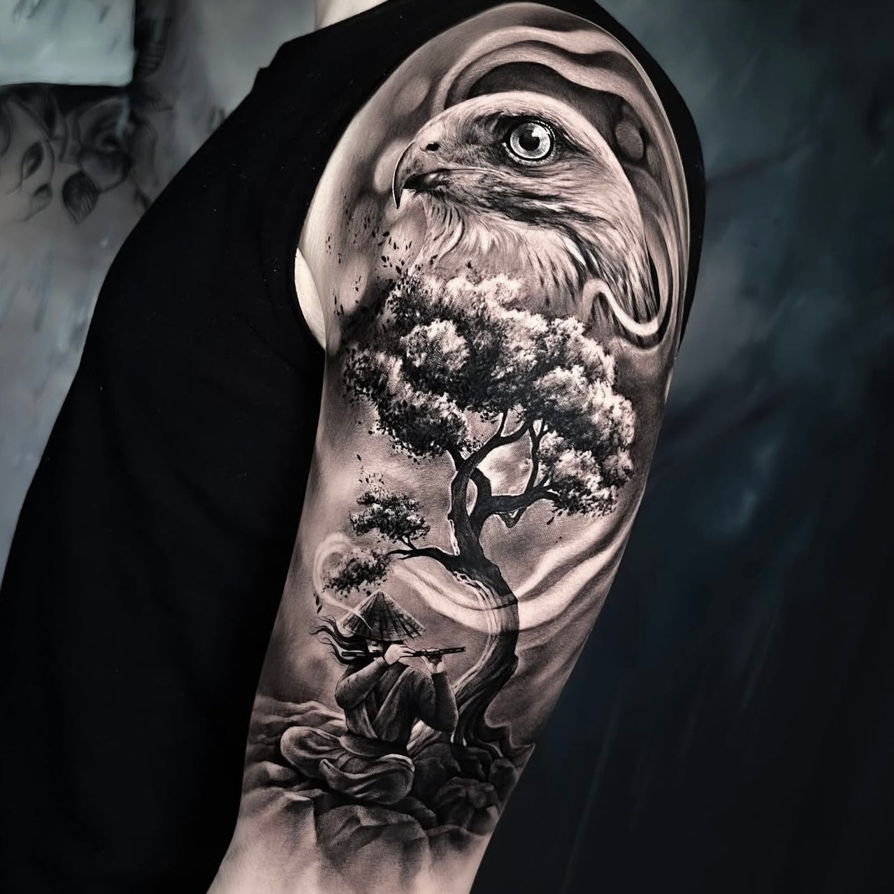 Tatuagem realista em black and grey de águia sobre bonsai e paisagem natural no braço, estilo realismo com inspiração oriental, feita na Dilúvio Tattoo em Benfica.