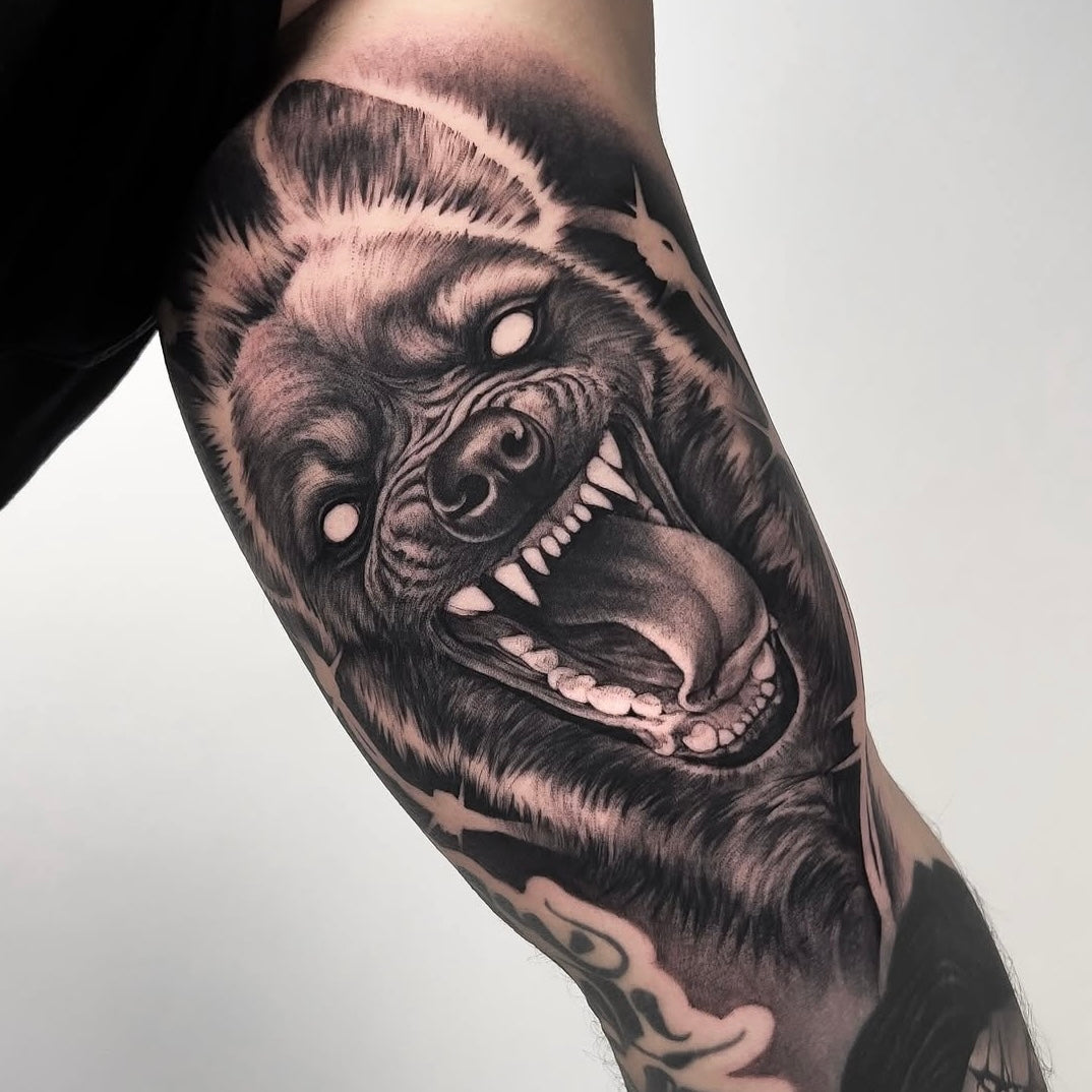 Tatuagem realista de cão a rosnar com dentes à mostra, black and grey, feita no Dilúvio Tattoo em Benfica, Lisboa.