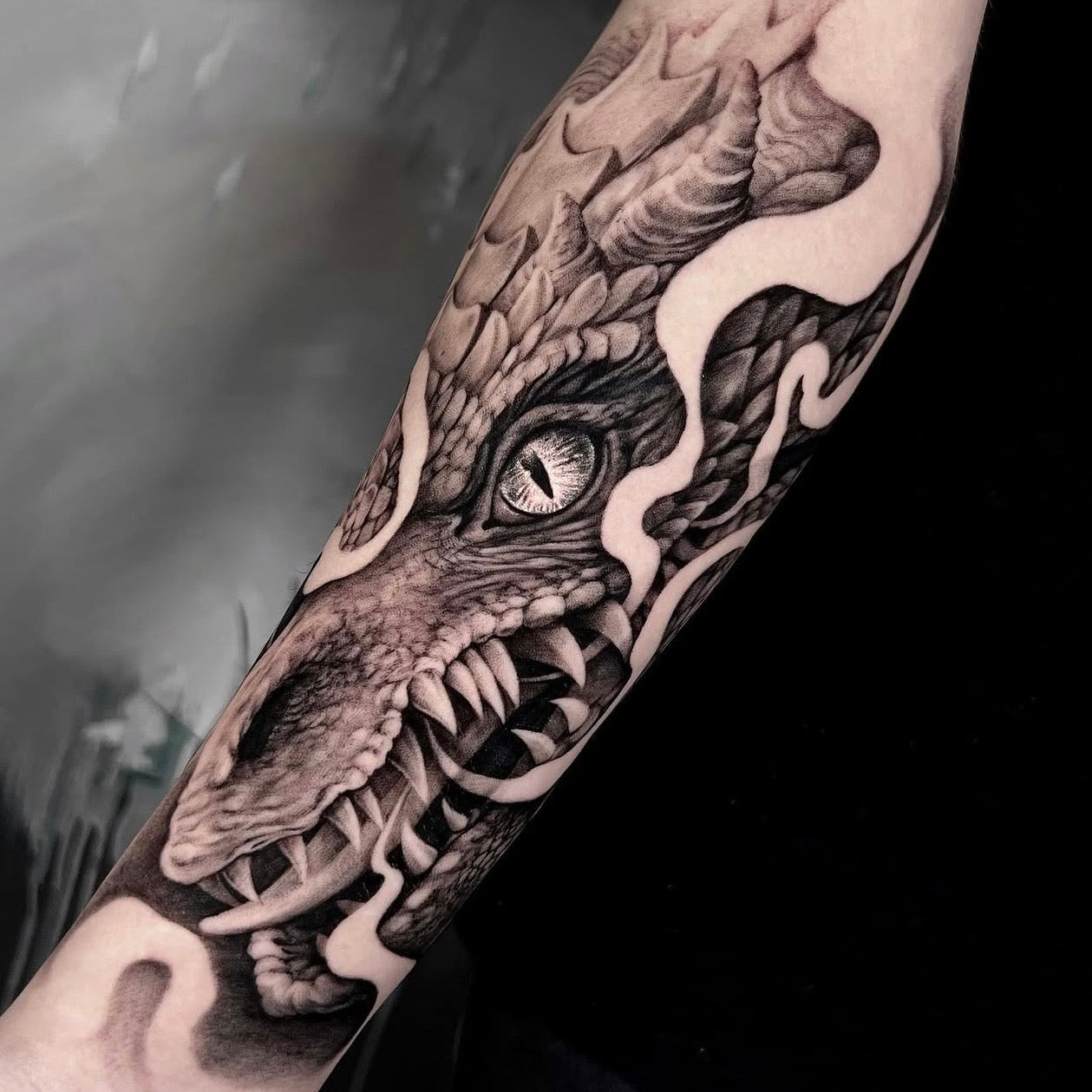 Tatuagem realista de cabeça de dragão com escamas detalhadas no antebraço, black and grey, feita na Dilúvio Tattoo em Benfica, Lisboa.