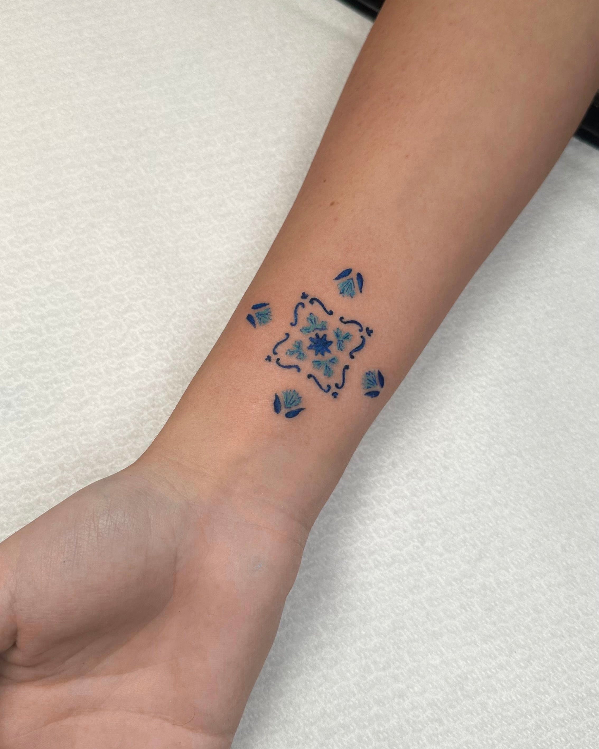 Tatuagem fine line de azulejo português tradicional a azul e branco no pulso, estilo cultural lusitano, feita no Dilúvio Tattoo em Benfica, Lisboa.