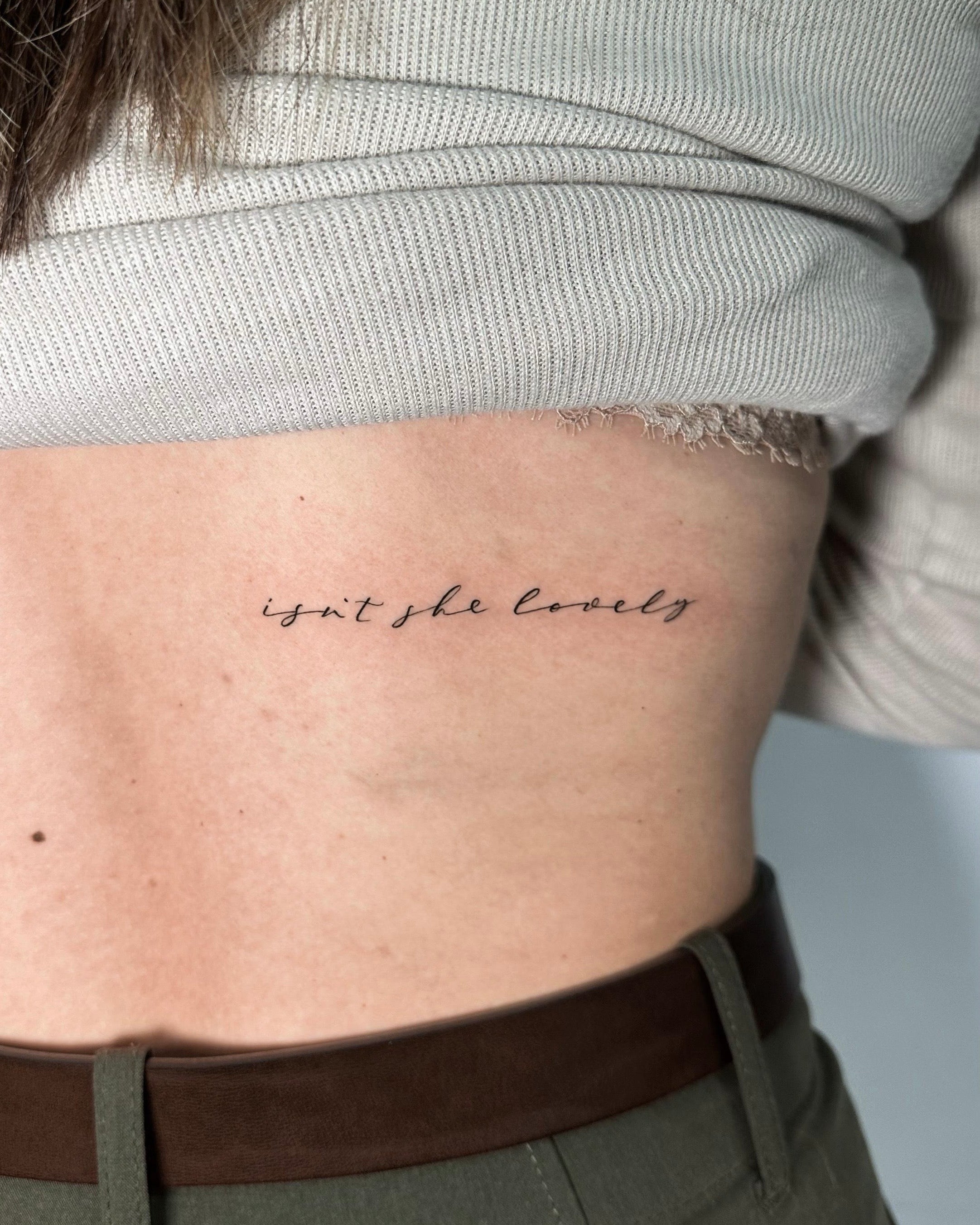 Tatuagem fine line de lettering cursivo 