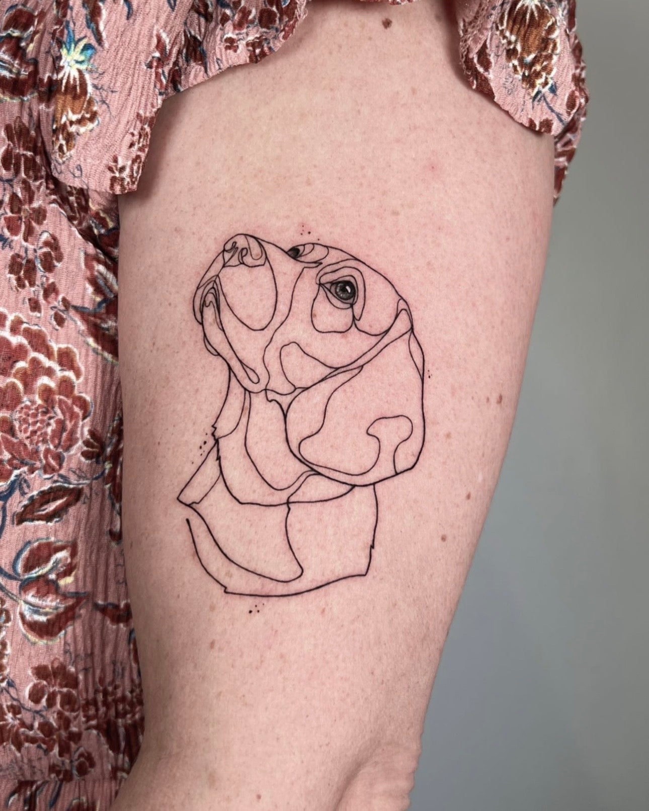 Tatuagem fine line de retrato de cão beagle em técnica de linha contínua no braço, estilo ilustrativo minimalista, homenagem a animal de estimação, na Dilúvio Tattoo em Benfica.