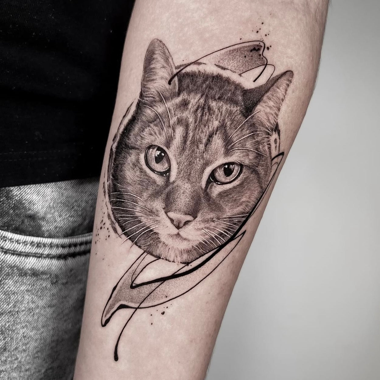 Tatuagem realista de retrato de gato com elementos abstratos e fine line no braço, black and grey estilo contemporâneo, homenagem a animal de estimação, na Dilúvio Tattoo em Benfica.
